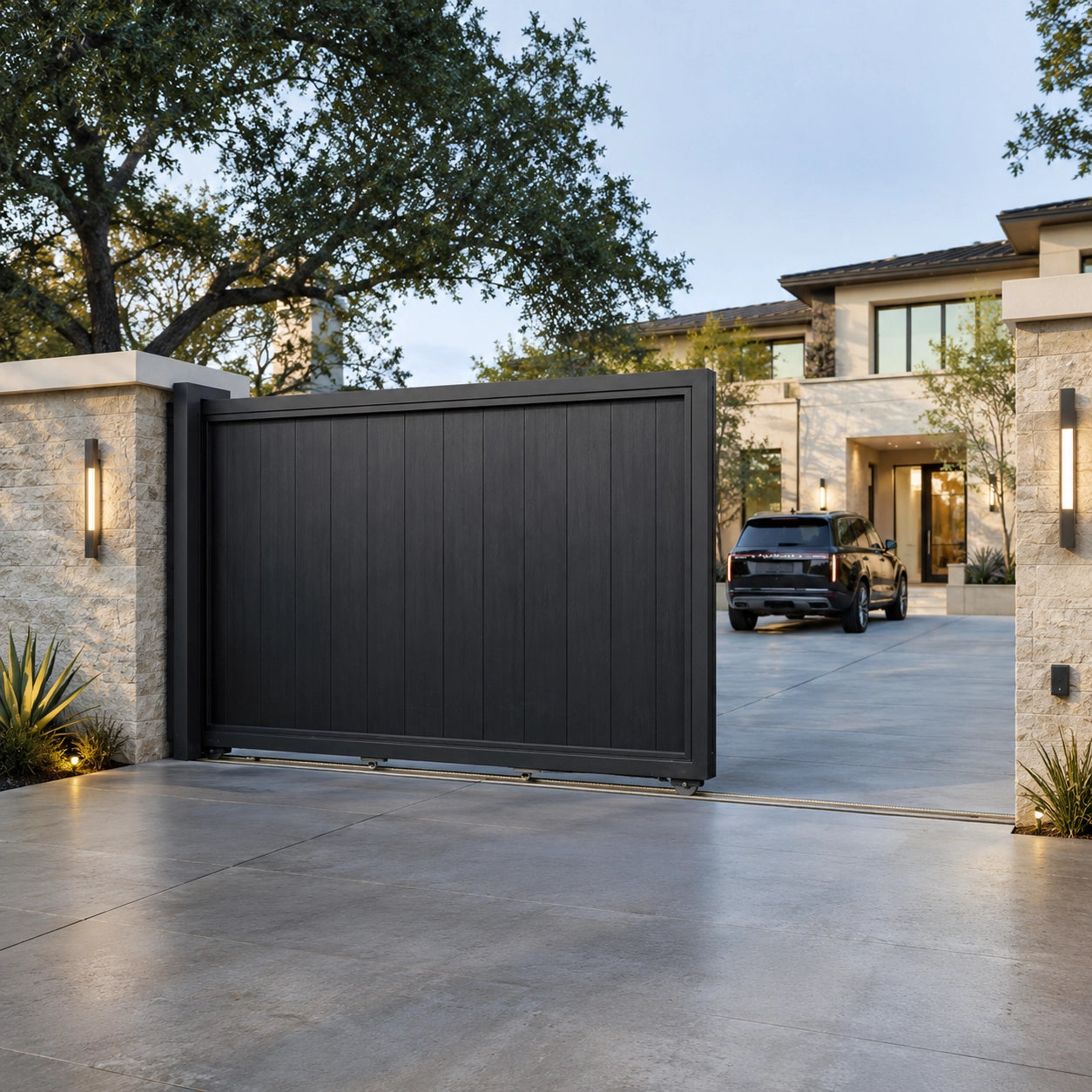 Track sliding driveway gate wide open showing spacious entrance for luxury residential property.